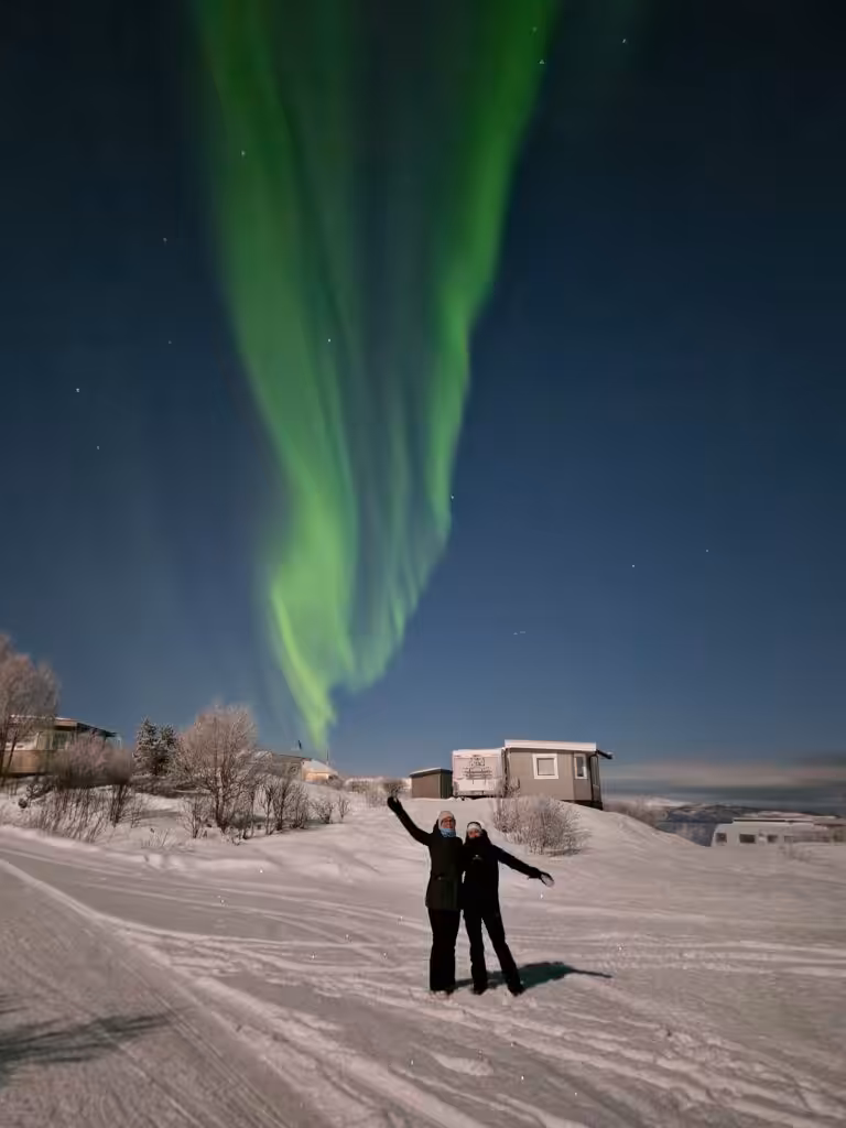 Par står under nordlyset.