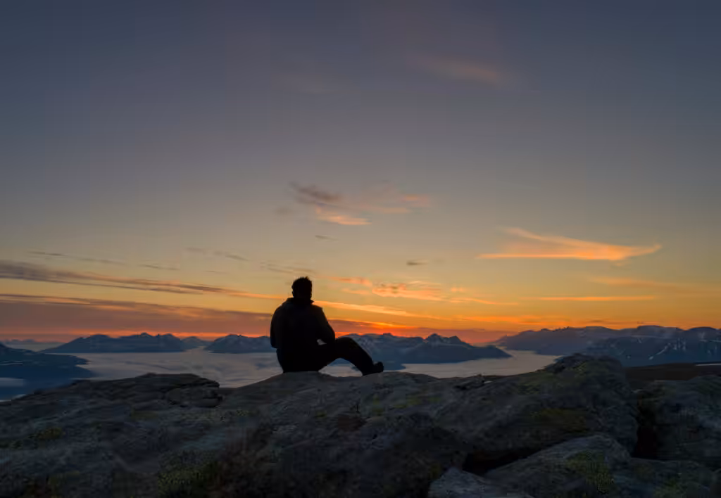 Silhouette auf einem Berggipfel bei Sonnenuntergang