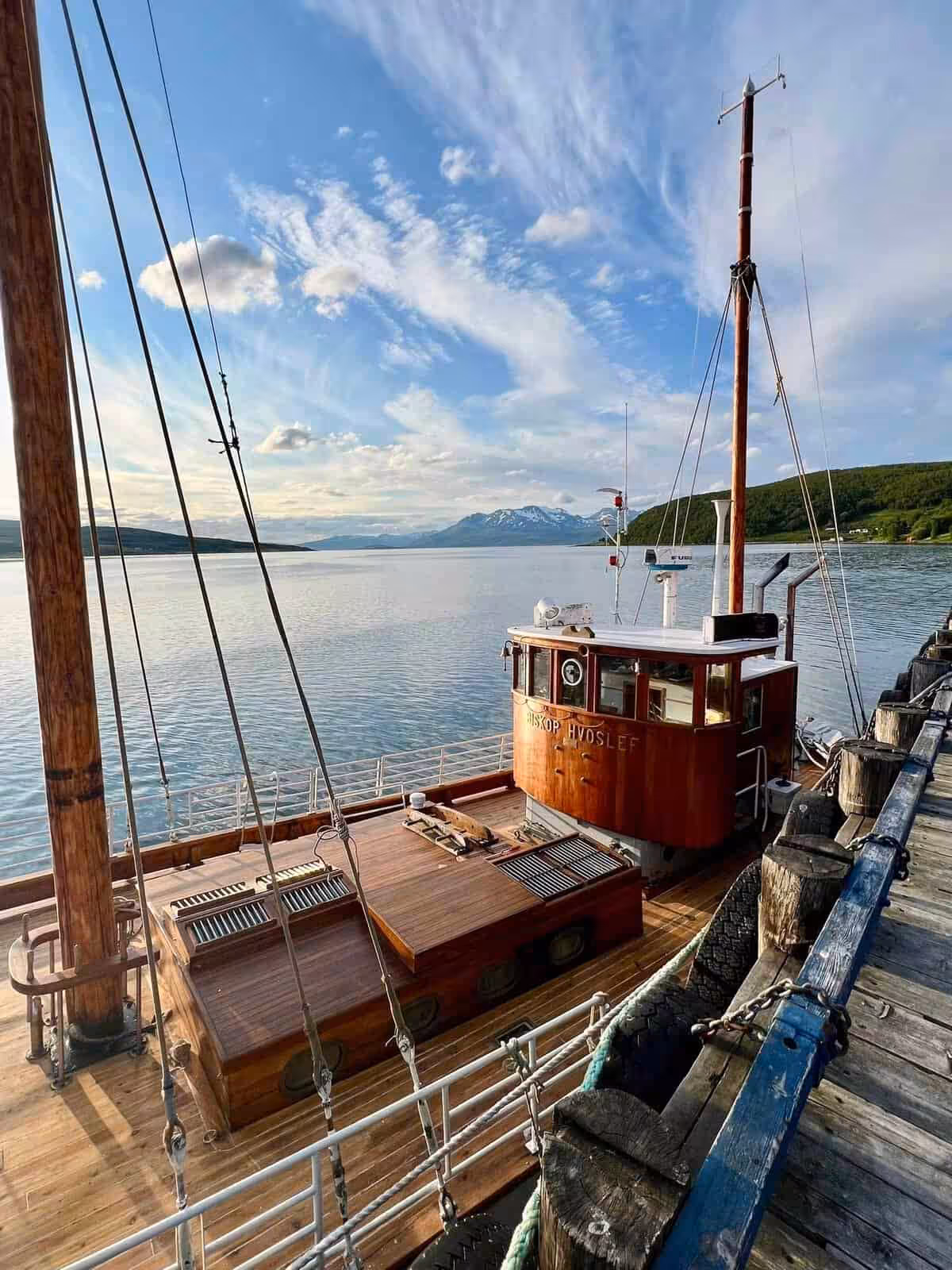 Trebåt ved bryggen omringet av natur.
