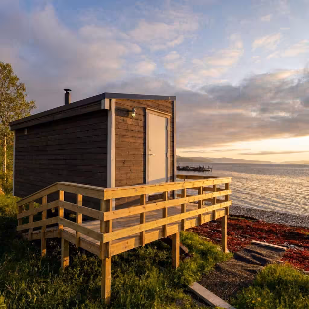 Petit bâtiment en bois au bord de l'eau au coucher du soleil