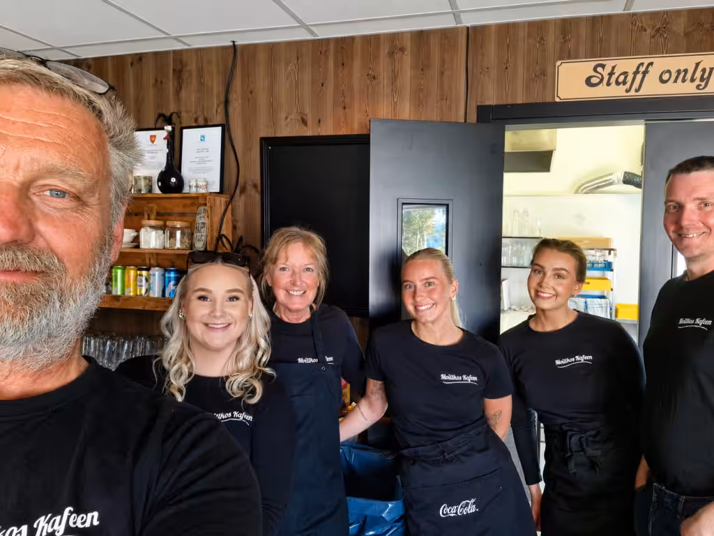 Ansatte samlet i et lite kafé- eller serveringsmiljø