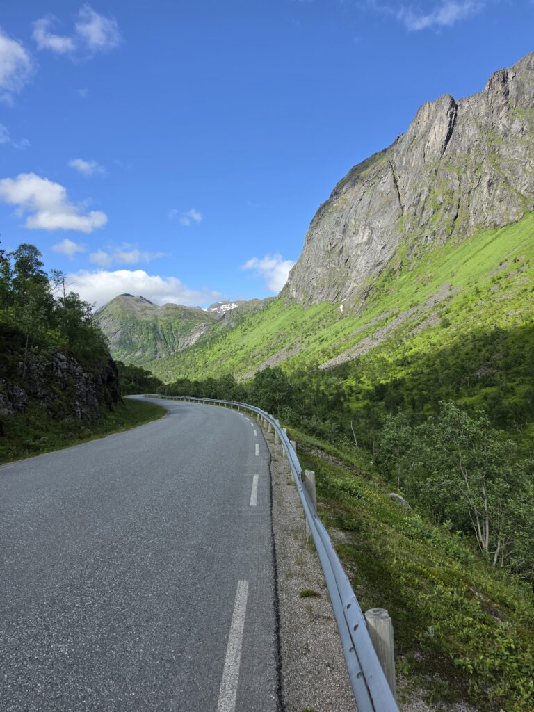 Svingete vei gjennom en grønn fjelldal
