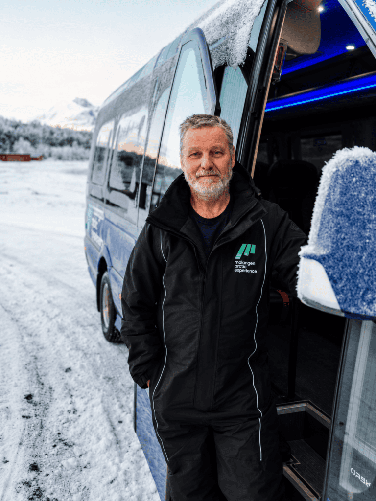 Mann ved buss i vinterlandskap